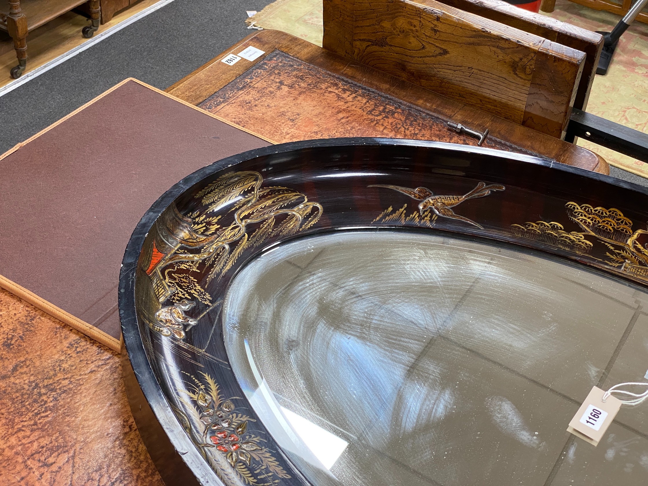An early 20th century oval chinoiserie lacquered oval wall mirror, width 117cm, height 78cm
